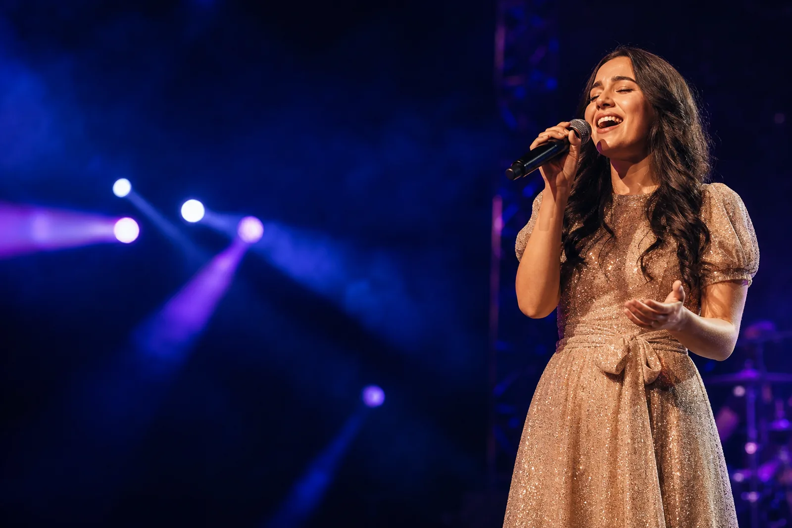 A performer singing on stage at a competition